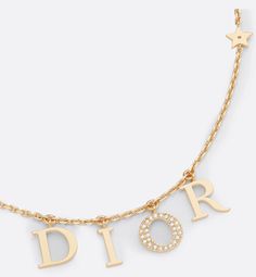 The Dio(r)evolution necklace is both elegant and timeless. The D.I.O.R. letters are suspended on a gold-finish metal chain, while the letter O is set with a pavé of white crystals for a touch of shimmer. The effortless style can be worn with other creations from the Dio(r)evolution line.. Dior Necklace Gold, Sweet 16 Jewelry, Dior Necklace, Pretty Jewelry Necklaces, Luxe Jewelry, Dior Jewelry, White Crystals, Classy Jewelry, Expensive Jewelry