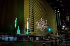 christmas lights decorate the side of a building at night