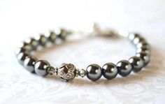 This artisan handcrafted beaded pearl bracelet is available in custom colors.  This crystal and pearl bracelet features beautiful dark grey Czech glass pearls with Swarovski grey hued bicone crystals set with antique silver ornate leaf petal bead caps.  This grey pearl bracelet for women is shown with antique silver plated toggle clasp, or an optional lobster claw or spring ring clasp.  A chain extender add on available.    Silver Plated crimps, crimp covers and wire guards.    Perfect for every Elegant Gray Bracelets As Gift, Elegant Gray Bracelets For Gift, Elegant Gray Bracelet As Gift, Elegant Pearl Bracelet With Spacer Beads For Wedding, Elegant Gray Bracelet For Gift, Elegant Gray Beaded Bracelets With Silver Beads, Elegant Hematite Beaded Bracelets With Silver Beads, Elegant Gray Beaded Bracelets, Elegant Hematite Beaded Bracelets With 8mm Beads