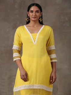 A three piece set comprising of a sunshine yellow kurta with pants. Curated in premium soft cotton, the kurta has lace detailing on the neck,hem and sleeves. Paired with straight cut soft cotton pants adding a slight organza touch to it ,it is finished with lace detailing. It comes with a colour block organza dupatta. Color: Yellow Fabric Composition: Kurta Set - Soft cotton Dupatta - Organza Note: The product will be delivered within 20-25 days of order placed Care Instruction: Dry Clean Only. Cotton Kurta With Lace Work For Eid, Cotton Kurta With Lace Work For Navratri, Yellow Cotton Silk Kurta For Spring, Fitted Cotton Kurta With Lace Work, Yellow Cotton Palazzo Set For Eid, Spring Yellow Cotton Silk Kurta, Yellow Cotton Salwar Kameez With Embroidered Border, Yellow Cotton Kurta With Embroidered Border, Cotton Bohemian Lace Work Sets For Diwali