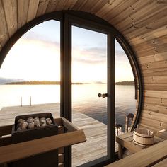 the inside of a wooden cabin with a hot tub and large windows overlooking a body of water