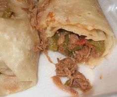 two burritos sitting on top of a white plate