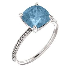 a blue topazte ring with white diamonds on the sides and an intricate band around it