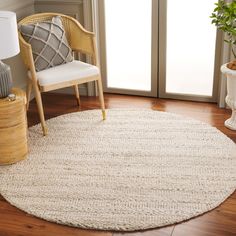 a white rug in the corner of a room with a chair and potted plant