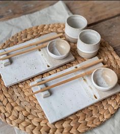 a plate with chopsticks and bowls on top of it next to napkins