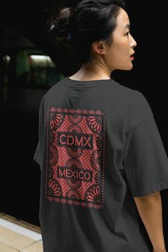 Welcome to our online T-shirt collection, where style meets culture! Introducing our vibrant and culturally rich CDMX Mexican Papel Picado T-shirt collection, inspired by the lively streets of Mexico City.   Celebrate the essence of Mexican tradition with our intricately designed Papel Picado T-shirts. Each shirt is a unique blend of contemporary fashion and traditional artistry, showcasing the intricate patterns and vibrant colors reminiscent of Mexican fiestas. Crafted with care and attention to detail, our T-shirts are made from premium quality materials, ensuring comfort and durability with every wear. Whether you're strolling through the bustling streets of CDMX or simply adding a touch of cultural flair to your wardrobe, our Mexican Papel Picado T-shirts are the perfect choice. Embra Festival Graphic Crew Neck Top, Festival Graphic Print Crew Neck Top, Festival Crew Neck Top With Graphic Print, Graphic Print Crew Neck Top For Festival, Cotton Graphic Design T-shirt For Festivals, Festival Crew Neck T-shirt With Graphic Print, Cotton Graphic T-shirt For Festivals, Graphic Cotton T-shirt For Festivals, Casual Tops With Graphic Print For Festivals