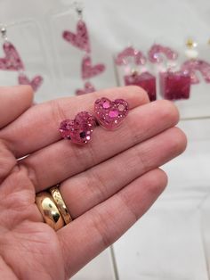 These are a pair of pink glitter resin heart shaped stud earrings. The stud is made of nickel free metal. Pink Heart-shaped Resin Jewelry, Pink Glitter Heart Earrings For Party, Pink Heart Resin Earrings, Pink Glitter Earrings For Valentine's Day, Pink Resin Heart Earrings As Gift, Valentine's Day Pink Glitter Earrings, Pink Resin Heart Earrings For Gift, Pink Resin Jewelry With Heart Charm, Cute Resin Heart Earrings For Valentine's Day