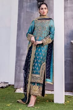 Premium Embroidered Pakistani Wedding Dress in Blue is a traditional masterpiece fully emblazoned with embroidery and gold-copper work. Perfect stitching and embellished borders make this beautiful Kameez Trouser an epitome of beauty and grace. Embellished Kameez: The beautiful kameez has an alluring blue shade and is adorned with hand-crafted details of zardosi and gold-copper details. Embroidery work around the borders and on the front of this kameez making it a perfect choice to wear at a wed Mehndi Suit, Suits Pakistani, Velvet Dress Designs, Latest Dress Design, Pakistani Wedding Outfits, Pakistani Wedding Dress, Pakistani Fancy Dresses, Pakistani Fashion Party Wear, Beautiful Pakistani Dresses