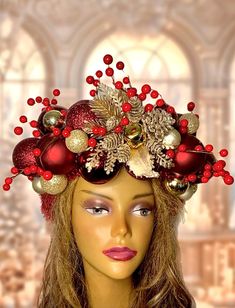 a mannequin headpiece with red and gold ornaments on it's head