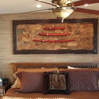 a bedroom with a bed, ceiling fan and pictures on the wall