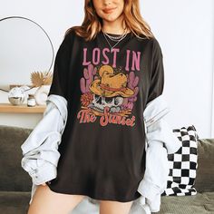 This Comfort Colors western desert shirt is perfect for summer in the wild west, a rodeo or country music concert. This western boho tee would be adorable with your fav cowboy boots for western summer style! * Ultra soft * Distressed design * Pre-shrunk * Universal fit * True to size * DTG Printing * Brand - Comfort Colors Refunds/Exchanges: * No Cancellations * No returns/exchanges * All sales are final Sizing: Our graphic tees and sweatshirts are a true to size standard unisex fit. For an oversized look, please size up. For a TShirt dress fit, we recommend sizing up at least two sizes. Please oversee the sizing chart provided in the listing photos to ensure your measurements are correct as we DO NOT offer cancellations, exchanges or returns. Shipping: All products are made to order and a Casual Crew Neck Shirt For Rodeo, Casual Letter Print Shirt For Rodeo, Western Tops For Country Concerts In Summer, Summer Graphic Print Shirt For Rodeo, Casual Shirt With Letter Print For Rodeo, Summer Graphic Print Tops For Rodeo, Western Style Shirt With Graphic Print And Relaxed Fit, Graphic Print Tops For Summer Rodeo, Western Style Graphic Print Shirt For Summer