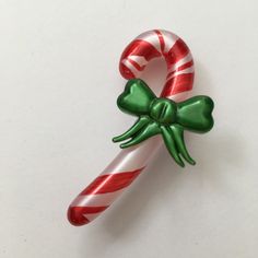 two candy canes with green and red bows on them sitting next to each other