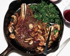 a skillet with meat, mushrooms and spinach