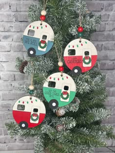 three camper ornaments hanging from a christmas tree