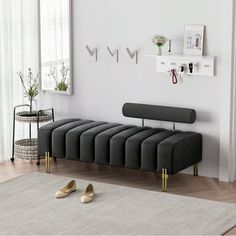 a modern living room with white walls and flooring, including a gray bench in the middle