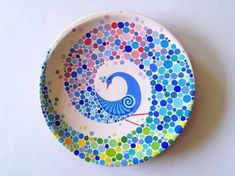 a colorful plate with dots on it and a bird painted on the side in blue