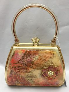 Debbie Brooks Brand New Evening Bag with handle  Gold PASTEL LEAVES Has Crystal embellishments Gold frame and hardware Gold Satin Pretty gold under lucite on the handle  Has an additional long snake strap (Gold Tone) And comes with a dust bag Approximate Measurements  5.75" width 4" (not including lock) 3 depth Please email me with any questions or for more pictures before bidding All my items come from a smoke/pet free home No returns unless an item is grossly misrepresented Happy bidding! Designer Handheld Clutch With Top Carry Handle, Designer Gold Tote Box Bag, Designer Handheld Evening Bag For Daily Use, Designer Handheld Satchel As Gift, Gold Box Bag With Top Carry Handle, Designer Handheld Evening Bag With Top Handle, Designer Evening Bag With Detachable Handle, Gold Tote Box Bag With Top Carry Handle, Formal Multicolor Shoulder Bag With Removable Pouch