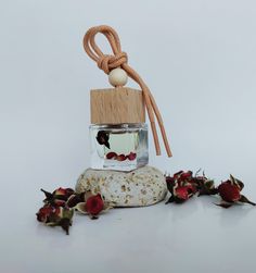 a glass bottle filled with water sitting on top of a rock next to dried flowers