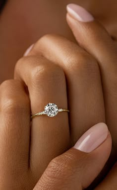 a woman's hand with a diamond ring on it