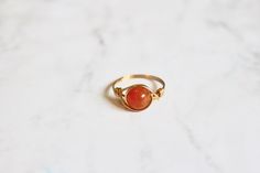 ♡ This listing is for 1 orange quartzite ring ♡ A dainty wire wrapped orange quartz ring. Wrapped in your choice of gold, silver or copper wire. {Details} 💍 * 8mm orange quartz (dyed) gemstone * Non tarnish rich gold (pictured), yellow gold or silver wire - choose wire before adding to cart * Available in sizes 3-13 including half sizes - choose size before adding to cart {About Fire Agate}  Fire Agate is a protective and grounding stone with a calming energy. It is also believed to instill bra Adjustable Handmade 14k Gold Filled Ring, Handmade 14k Gold Filled Rings, Wire Wrapped 14k Gold Filled Rings Perfect For Gifts, Handmade Agate Moonstone Ring Gift, Wire Wrapped 14k Gold Filled Rings As Gift, 14k Gold Filled Wire Wrapped Rings As Gifts, Minimalist Handmade Agate Jewelry, Handmade Minimalist Agate Jewelry, Handmade Gold Agate Ring