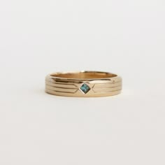 a gold ring with a blue stone in the center and two thin bands around it