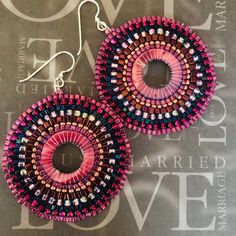 Viva Magenta Earrings Seed Bead Dangle Hoop Earrings  Boho style large hoop earrings created with pink shell rings beaded with magenta, maroon  and copper seed beads.  These beautiful earrings are woven on pink shell peal beads.  Each bead is individually hand sewn and expertly woven to make these beautiful earrings. The  earwires are sterling silver.  These large, bold, statement earrings measure approximately 2 inches. The discs are 1.5 inches. Lightweight and fun to wear. Great for any styles Bohemian Small Hoop Beaded Earrings With Ear Wire, Bohemian Beaded Small Hoop Earrings With Ear Wire, Bohemian Small Hoop Beaded Earrings, Bohemian Pink Beaded Earrings, Bohemian Small Hoop Beaded Earrings With Dangling Beads, Handmade Small Hoop Bohemian Beaded Earrings, Bohemian Purple Hoop Earrings With Round Beads, Handmade Pink Circle Earrings, Handmade Pink Circular Earrings