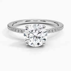 a round cut diamond ring with pave set shoulders