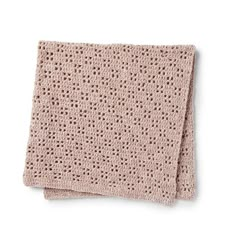 a pink knitted blanket on top of a white surface