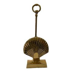 an antique brass fan on stand against a white background