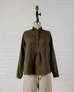 Long sleeve top with a small collar to wear up or down, mother of pearl button front and cuffs. Small gather at bottom of button front. Easy to wear on it's own, or layered under another top, jacket or sweater.  100% Linen. Made in the U.S.A. All of our pieces have been pre washed and dried to minimize any shrinkage. W Blouse With Buttons And Fold Down Collar, Long Sleeve Tops With Buttons For Fall, Daywear Blouse With Fold Down Collar And Buttons, Daywear Blouse With Buttons And Fold Down Collar, Relaxed Fit Tops With Button Closure For Fall, Classic Fall Tops With Placket, Cotton Button-up Top With Smocked Cuffs, Fall Tops With Smocked Cuffs And Relaxed Fit, Casual Long Sleeve Top With Smocked Cuffs