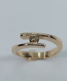 This handmade, beautiful  ring has been expertly crafted in warm 10k yellow gold and authentic Champagne diamonds. This gorgeous ring will make a great any occasion/Christmas gift. All of my jewelry is handmade from scratch, one item at a time as I like to make sure I am producing a high quality piece. Upon request a personalized message can be added to the inside of the ring. A tracking shipping number will be provided to you once the ring has been shipped. Diamonds measurements: 1 Diamonds: 3. Gold Bypass Ring With Diamond Cut For Anniversary, Gold Diamond Cut Bypass Ring For Anniversary, Gold Ring With Tension Setting, Gold Tension Setting Round Band Ring, Yellow Gold Bypass Ring With Tension Setting, Gold Solitaire Ring With Open Band, 14k Gold Ring With Tension Setting, Gold 14k Tension Setting Ring, Gold Solitaire Birthstone Ring Open Shape