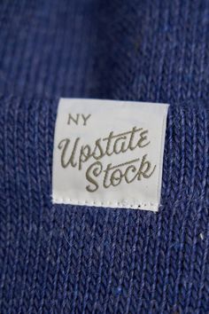 a label on a blue sweater that says, my up state stock