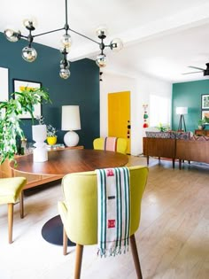 a living room filled with furniture and a wooden table in front of a green wall