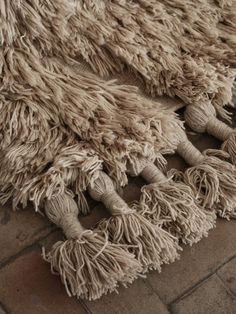 a pile of shaggy rugs laying on top of a brick floor