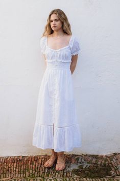 Our most epic romantic dress is here. The Mary dress is a delicate white long dress in a dreamy cotton textile. It features a round neckline, gathered bust and petite ruffles. Its stretchy smocked bodice finishes with a delicate crochet trimming, and gives way to a full-length skirt with in a big ruffle at the bottom. 100% cotton Maxi length BSCI certified. Made in India. Knee-length Smocked Dress With Ruffles For Daywear, Casual Midi Dress With Ruffled Fitted Bodice, Daywear Smocked Dress With Ruched Ruffled Straps, Ruched Smocked Dress With Ruffled Straps For Daywear, Knee-length Smocked Dress With Ruffles For Garden Party, Feminine Cotton Midi Dress With Ruffle Hem, Midi-length Smocked Dress With Ruffles For Garden Party, Cotton Smocked Midi Dress With Ruffles, Midi Length Smocked Dress With Ruffles For Garden Party