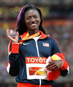 a woman in an orange and blue jacket holding a medal