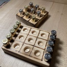 a wooden board game set up on top of a table with lots of brass and silver buttons