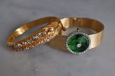 "Fine watch bracelet set with a jade donut and accented with diamonds in 18k. The donut is a deep green Omphacite jade, in parts dark and light like a globe lit. This jewel borrows the perfect finish of a Vacheron watch, its Omega straps in original burnished solid gold. More than a conversion piece, this bracelet could not have been refined to a sleeker layout. At 2cm, the donut is considered big yet its size is offset by the straps, and vice versa. The straps though wide feel made for its cent Timeless Green Jewelry With Single Cut Diamonds, Luxury Jade Jewelry For Anniversary, Fine Jade Jewelry For Formal Occasions, Luxury Oval Jewelry With Diamond Hour Markers, Formal Round Jade Jewelry, Evening Bracelets With Polished Finish, Timeless Green Jewelry For Evening, Timeless Green Evening Jewelry, Elegant Jewelry And Watches With Single Cut Diamonds