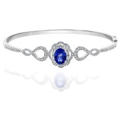 A unique and fashionable Sapphire bangle showcasing an openwork design set with 1.71 carat of Sapphire and 124 brilliant diamonds weighing 1.39 carat in total. Made in 18k white gold. Style available in different price ranges. Prices are based on your selection. Please contact us for more information. Luxury Oval Bangle For Formal Occasions, Oval Diamond Bangle Fine Jewelry, Oval Diamond Bangle In Fine Jewelry Style, Oval Gemstone Bangle For Formal Events, Luxury Oval Bangle For Anniversary, Fine Jewelry Oval Diamond Bracelet, Luxury Oval Gemstone Bangle, White Gold Oval Bangle For Formal Occasions, Oval Hand Set Bangle For Anniversary