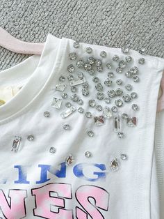 Graphic T-Shirt Cropped Loose Fit Rhinestone Detail On Shoulders Rolling Stones Paired With "Icy Girl" Shorts 95% Cotton 5% Spandex Spring Stretch Tops With Rhinestones, Stretch Crew Neck Top With Rhinestones, Cotton Rhinestone Short Sleeve Top, Rhinestone Cotton Tops With Short Sleeves, Cotton Short Sleeve Top With Rhinestones, Cotton Tops With Rhinestones And Short Sleeves, Casual White T-shirt With Rhinestones, Summer Rhinestone Short Sleeve Tops, Summer Short Sleeve Tops With Rhinestones