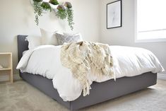 a bed with white sheets and pillows in a bedroom