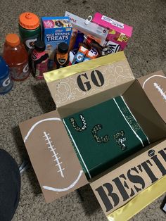 two boxes that have football themed items in them on the floor next to other things