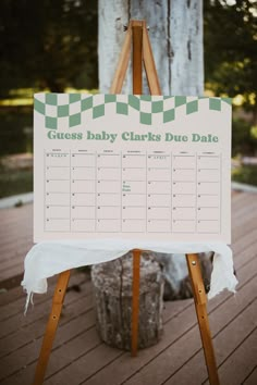 a wooden easel holding a sign that says guess baby clarks duee date