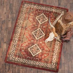 an old rug with a longhorn steer skull on it and a cowboy's hat next to it