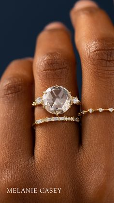 a woman's hand wearing a ring with an oval shaped stone and diamond band