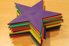 a star made out of colored paper sitting on top of a wooden table