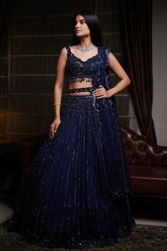 Navy blue lehenga with attached cancan, highlighted with sequin-cutdana and resham embroidery. Comes with cutwork V-neckline padded blouse, dupatta and belt.
Components:4
Embroidered
Neckline:V-Neck
Sleeve Length:Sleeveless
Fabric:Net
Color:Blue
Embroidered blouse with cutwork hem
Beaded tassels
Low back neck with tie-up
Embroidered scallop edged dupatta and belt - Aza Fashions Lahenga Design For Reception, Glitter Lehenga, Navy Blue Lehenga, Gown Dress Party Wear, Indian Dress Up, Bridal Lehenga Online, Reception Bride, Sangeet Outfit, Party Reception