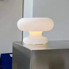 a white lamp sitting on top of a metal table