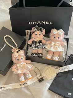 two teddy bears are sitting in front of a chanel bag and some other items