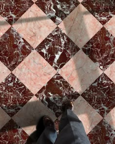 a person standing on a tiled floor with their feet in the air and one foot up